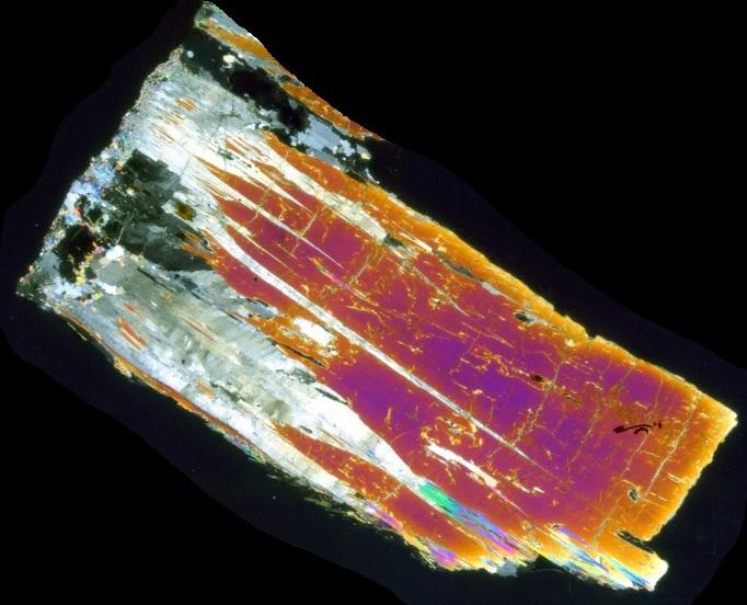 Cross-polarized image of kyanite (pink-orange) overgrowing andalusite (gray), ~3 cm in long dimension